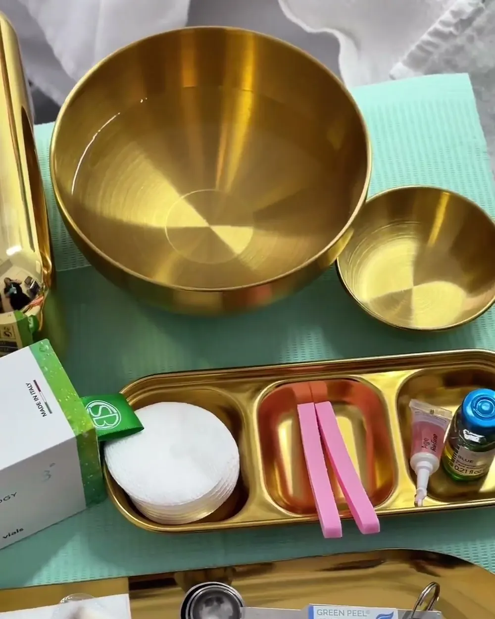 Gold bowls and trays of tools laid out for a treatment