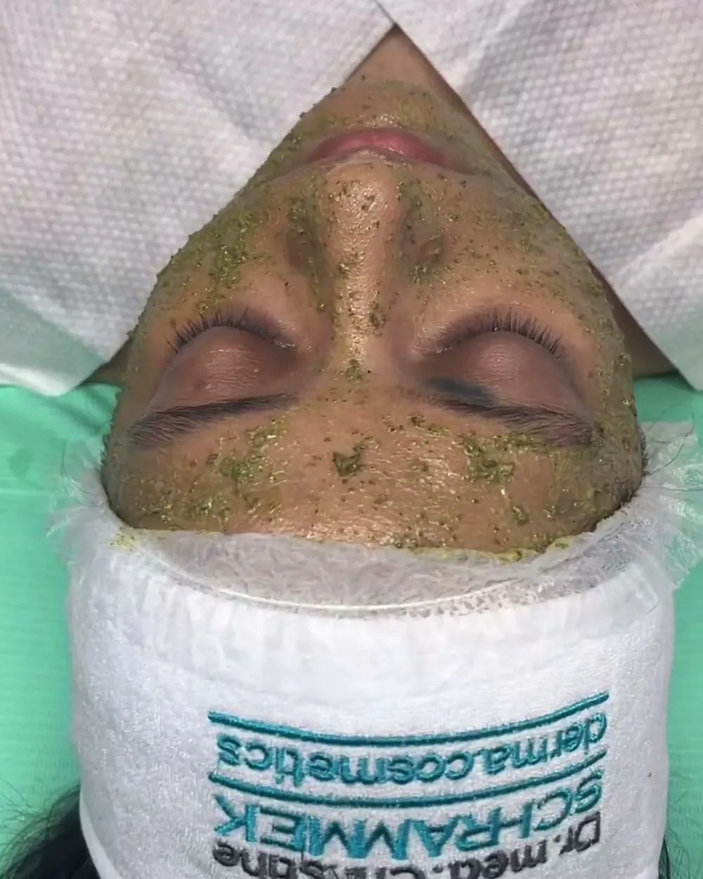 A Green Peel mask on a client, on a Dr. Schrammek towel